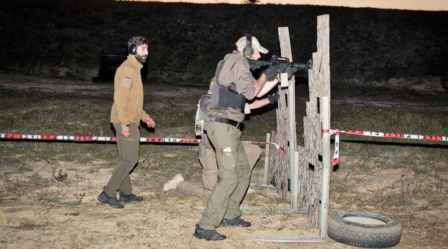 3. International Bodyguard Conference 2018 Teilnehmer trainieren hinter Spanplatten das Schießen aus der Deckung.