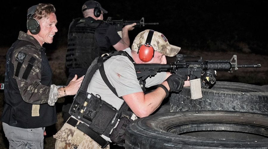3. International Bodyguard Conference 2018 Hinter Reifen trainieren zwei Teilnehmer im Dunkeln das Zielen mit mechanischer Visierung.