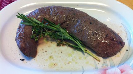 Weihnachtliches Jagdrezept Der Rehrücken wird mit Kräutern scharf in der Pfanne angebraten.