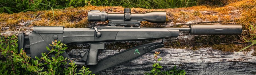 Dentler DR21 Testtage: Innovative Repetierbüchse selber Testen – alle Termine und Schießstände im Überblick Dentler DR 21 im Revier auf einem Baumstamm abgelegt. Montiert sind Schalldämpfer und Zielfernrohr.