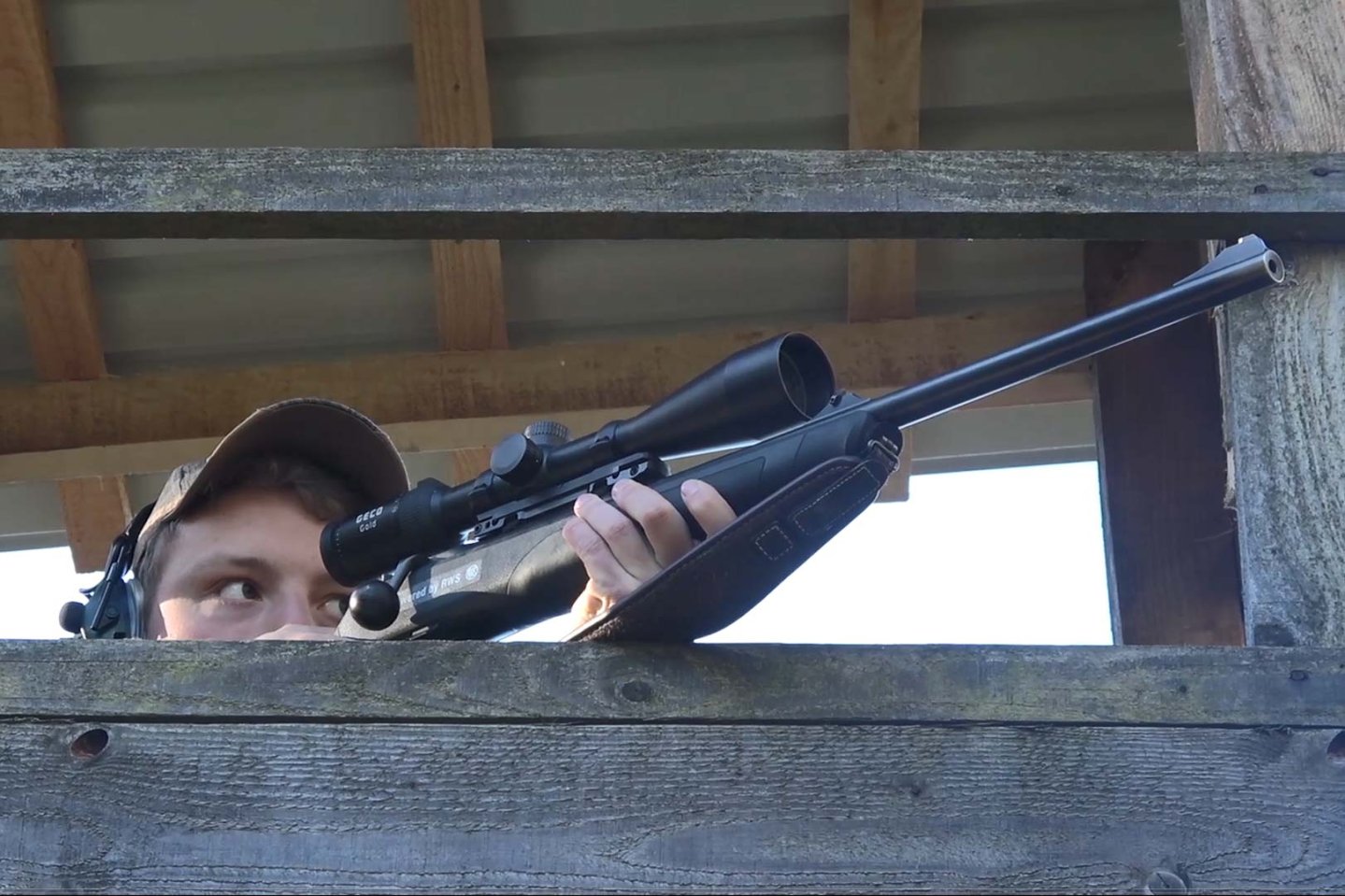 Welche Vorteile bietet die RWS HIT für passionierte Rehwildjäger? Jäger bei der Ansitzjagd auf einer Kanzel mit Jagdgewehr im Anschlag.