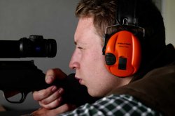 Bockjagd in der Blattzeit: bleifreie Munition RWS HIT im Test Jäger mit Gehörschutz blickt durch Zielfernrohr.