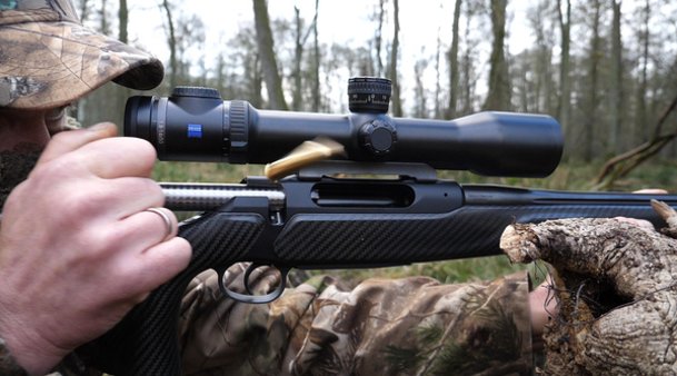Jäger lässt Kugel aus Jagdrepetierer mit montiertem Zielfernrohr fliegen