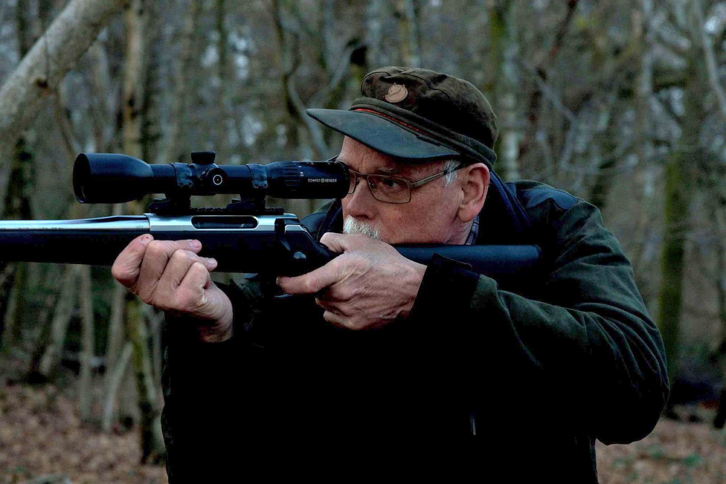 Jäger mit Zielfernrohr in der Dämmerung