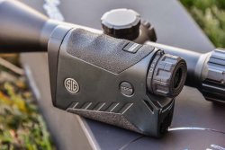 Brandneue Jagdoptiken: SIG Sauer BDX Electro-Optics-Modellreihe Bluetooth-fähiger SIG Sauer KILO 2200 BDX Laser-Entfernungsmesser liegt neben SIG Sauer SIERRA 3 BDX Zielfernrohr auf Verpackung