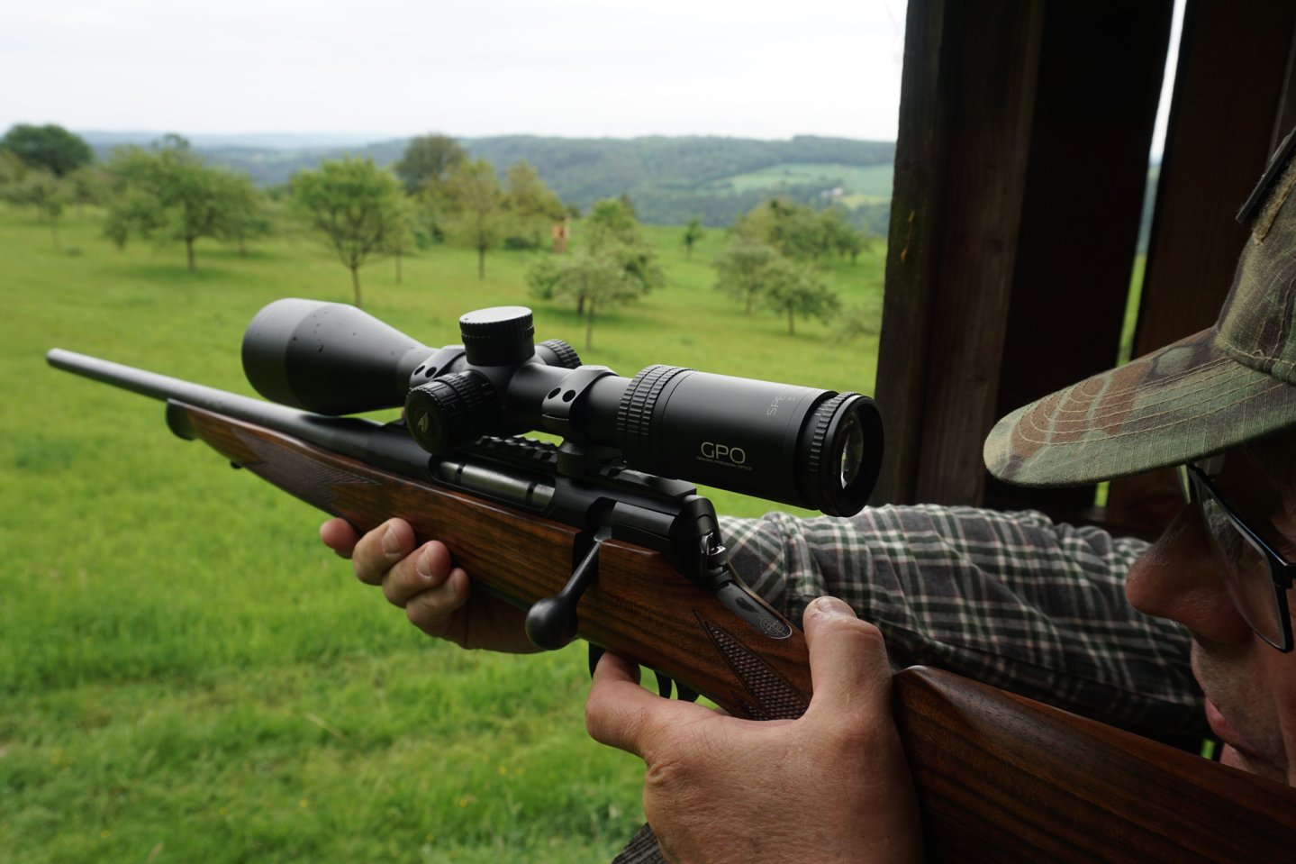 Was kann das neue Zielfernrohr GPO SPECTA 6x 3-18x56i G4i Fiber mehr als andere Jagdoptiken dieser Preisklasse? Ein Jäger zielt mit dem auf einer RöWa Signature Linkssystem montierten GPO SPECTRA 6x 3-18x56i aus einer Kanzel heraus.