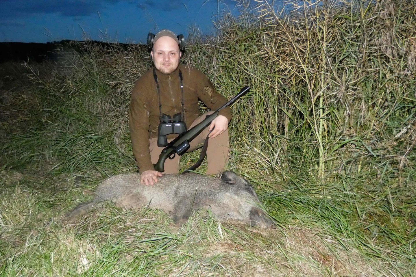 Hunting Felix auf Schwarzwildjagd: Meine erste bleifreie Sau! Das Erlegerbild zeigt den passionierten Jäger Hunting Felix mit einem erlegten Überläuferkeiler am Rapsfeld.