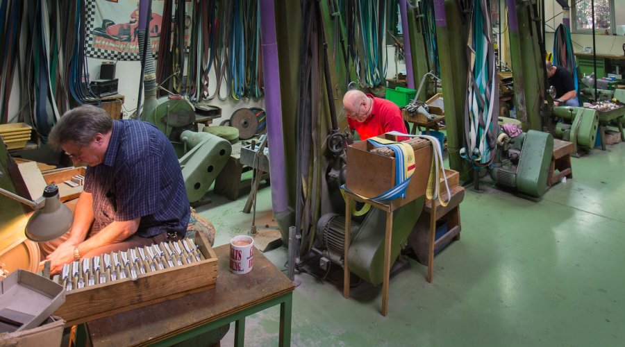 Mitarbeiter an den Bandschleifern im Werk von PUMA in Solingen.