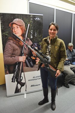 Blaser Neuheiten 2017 Frau hält Blaser R8 in der Hand vor Plakat.