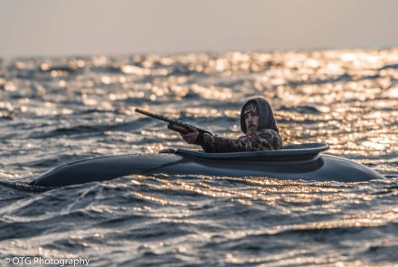Dream Hunt: Entenjagd in Maine, USA mit Fotograf, Filmemacher und Abenteurer Ryan Baudhuin Seitenansicht von Entenjaeger Ryan Baudhuin auf dem Lake Huron in einem Layout-Boot