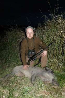 Hunting Felix auf Schwarzwildjagd: Meine erste bleifreie Sau! Jäger posiert an Rapskante mit erlegtem Keiler.