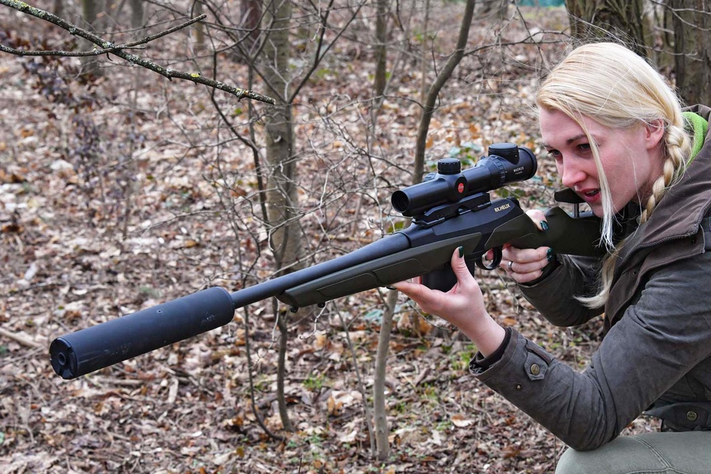 Jägerin mit Schalldämpfer und Jagdgewehr.