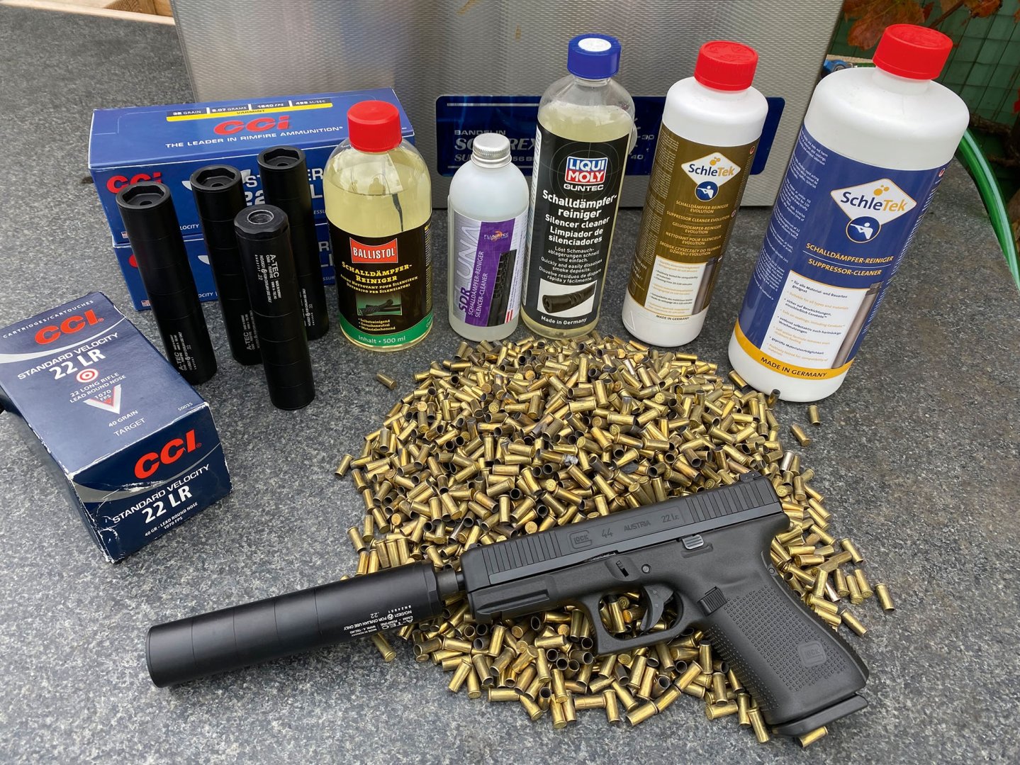 Der Testaufbau: eine Glock 44 mit insgesamt 5 A-Tec CMM4-SChalldämpfern und die Schalldämpferreiniger von Ballistol, Fluna Tec, Liqui Moly sowie SchleTek.