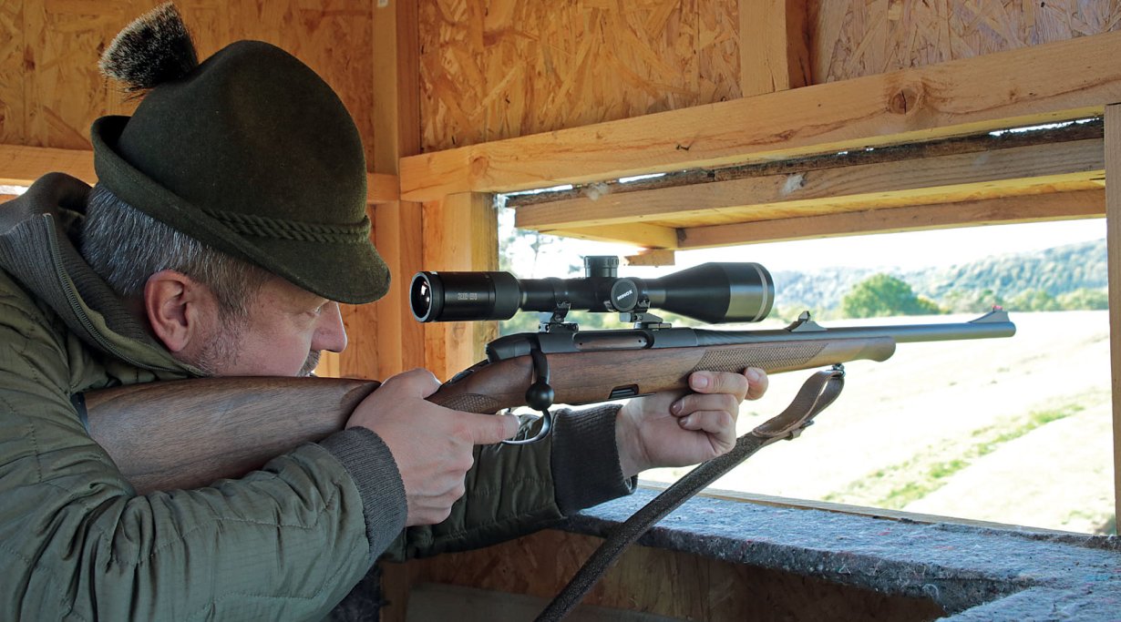 Jäger mit Repetierbüchse im Anschlag in Kanzel.