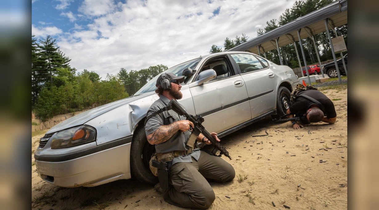 Eine Zwei-Mann-Schießübung mit dem SIG Sauer M400 TREAD, die Schützen sind hinter einem Auto in Deckung gegangen.