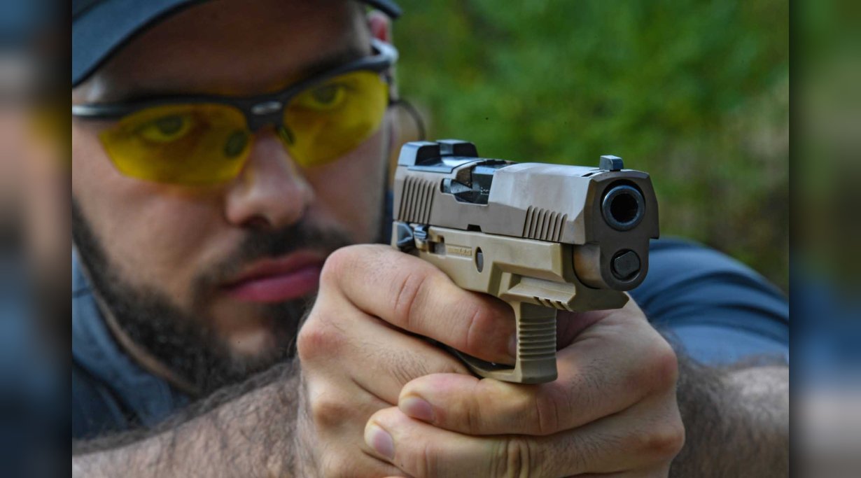Blick von vorn auf Schützen beim Testschießen der Pistole SIG Sauer P320-M17 in 9 mm Luger
