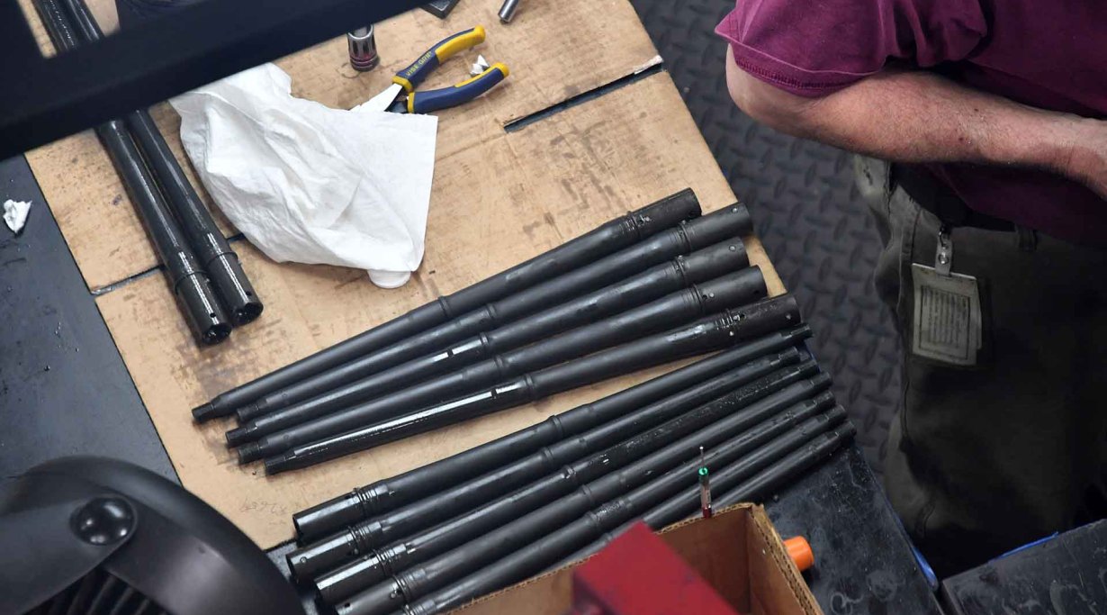 Eine Reihe von Läufen für das SIG Sauer MCX Selbstladegewehr liegt vor der Bearbeitung auf einer Werkbank