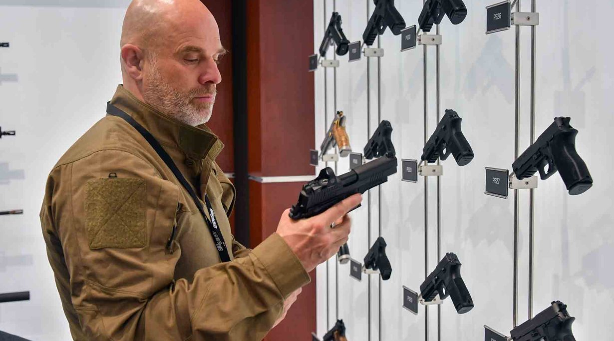 Schütze begutachtet Pistolen im Showroom des SIG Sauer USA Headquarters