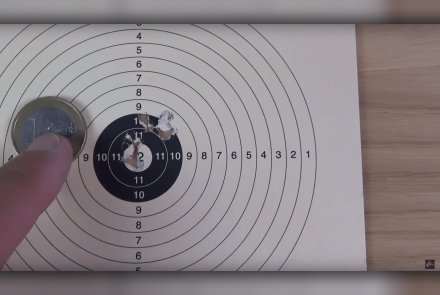 Test + Video: GAMO Replay 10 Maxxim IGT Knicklauf-Luftgewehr mit Mehrschussmagazin Luftgewehrscheibe mit Schussbild des Knicklauf-Luftgewehrs GAMO Replay 10 Maxxim IGT neben einer 1-Euro-Münze.