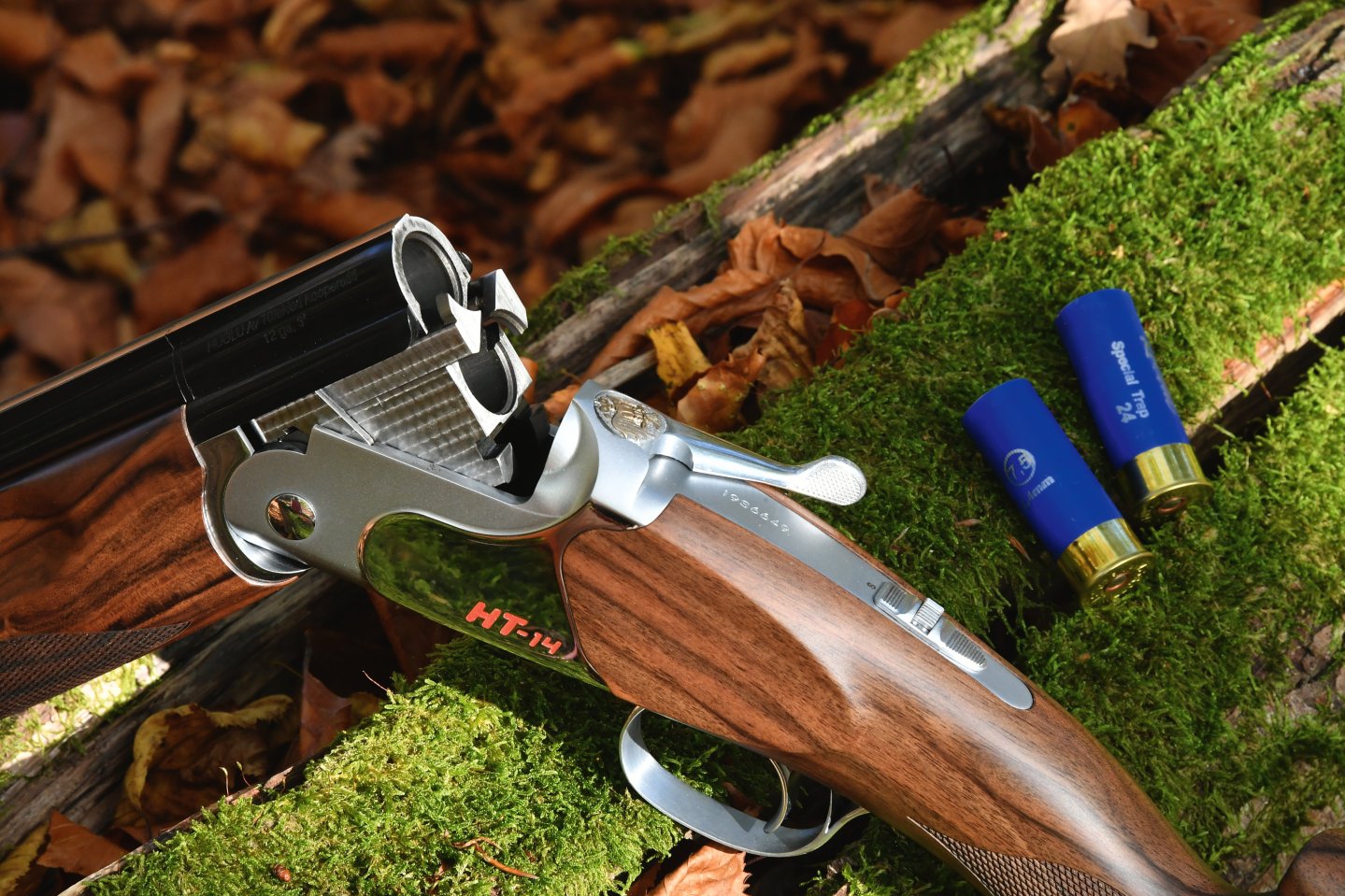 Praxistest Huglu HT-14 Sporting. Was bringt die primär für das Wurfscheibenschießen konzipierte Bockflinte im Kaliber 12/76 dem Sportschützen und dem Jäger? Die geöffnete Bockflinte Huglu HT-14 Silver auf einem Baumstamm abgelegt.