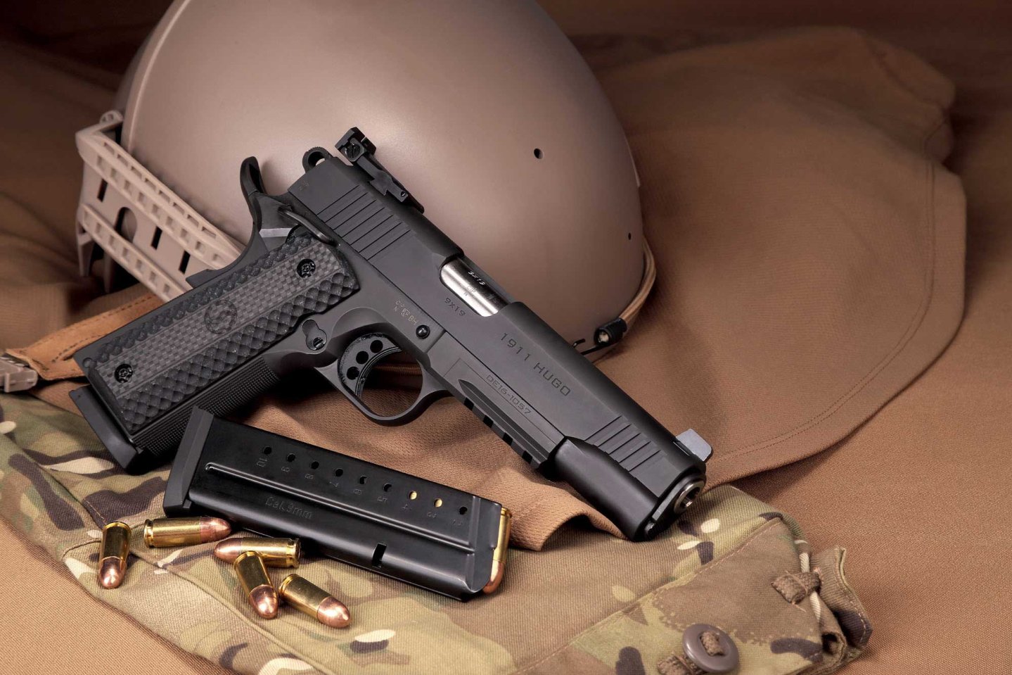 Test & Technik: Schmeisser 1911 Hugo Pistole im Kaliber 9 mm Luger Die Pistole Schmeisser 1911 Hugo liegt neben einem Magazin und Patronen im Kaliber 9mm Luger an einen Stahlhelm angelehnt.