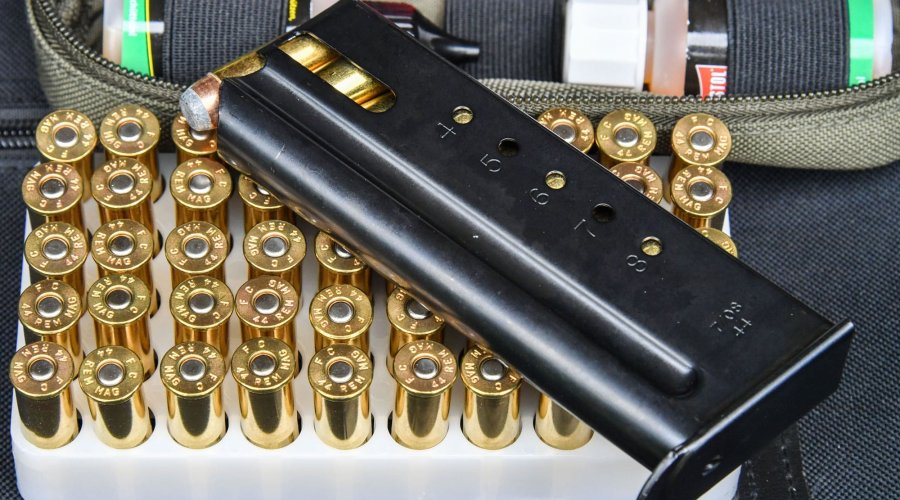 Magazin der halbautomatischen Pistole Desert Eagle XIX 6" Case Hardened von Magnum Research auf einer Packung Patronen