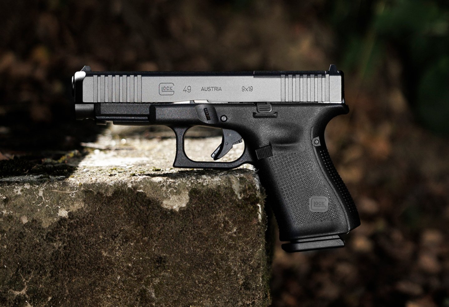 Die neue GLOCK G49 Gen5 MOS in 9 mm Luger von der linke Seite, abgestellt auf einer Betonstufe, zu sehen.
