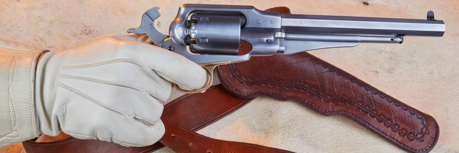 Vorderladerrevolver im Test: Der Pedersoli Remington Pattern Custom im Kaliber .44 Pedersoli Remington Pattern Custom Hand mit Handschuh greift den Revolver. Der Hahn ist gespannt.