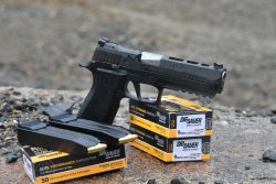 SIG Sauer P320 X-Five – Modularität at its best SIG Sauer P320 X-Five Matchpistole steht zwischen Packungen mit Munition im Kaliber 9 mm Luger und 2 doppelreihigen Magazinen