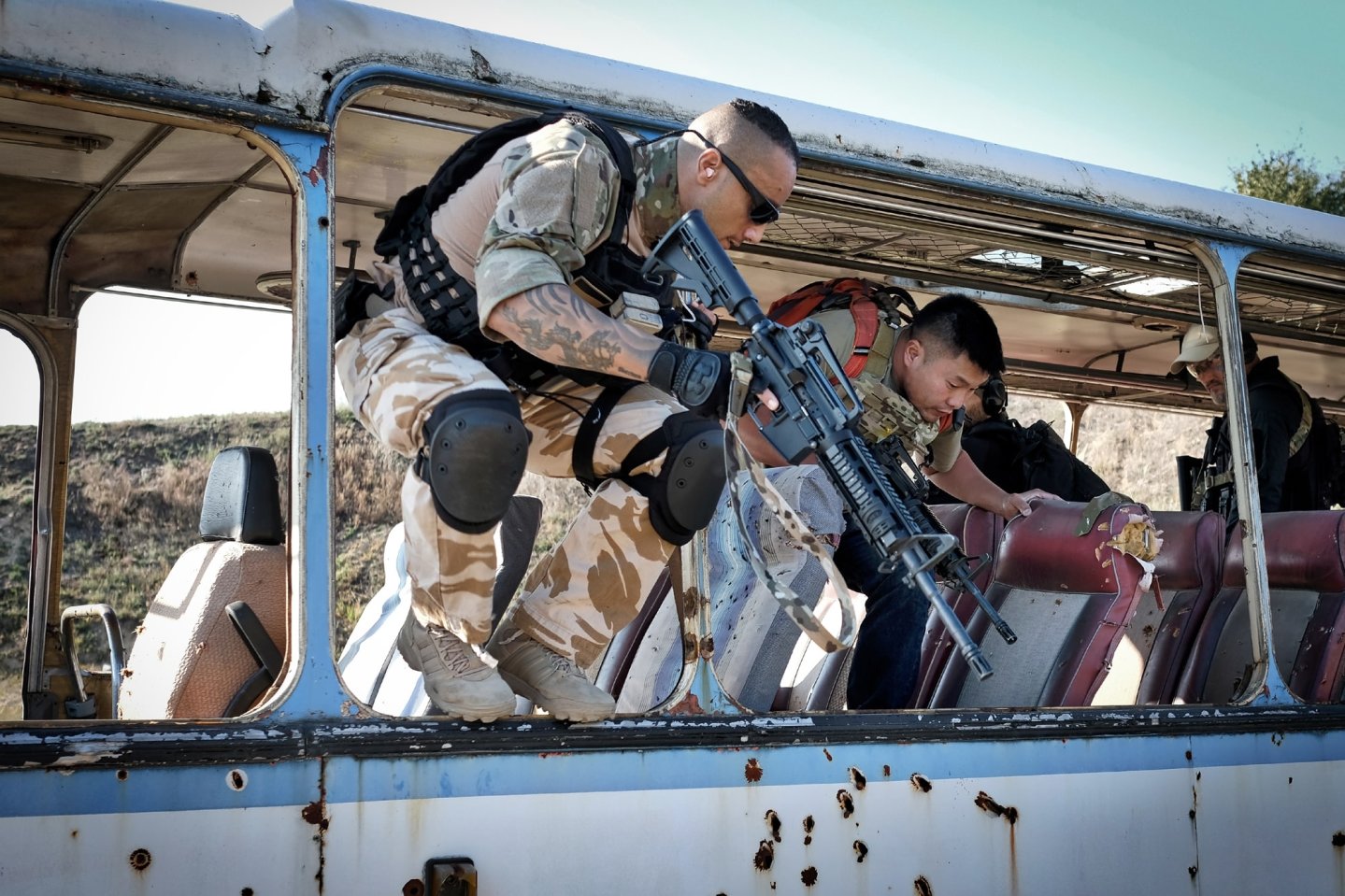 3. International Bodyguard Conference 2018 Zwei Teilnehmer mit AR-15-Gewehren springen aus einem Bus.