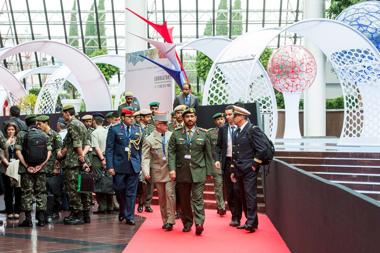 EUROSATORY 2018: mehr Platz für Verteidigung und Sicherheit Mehrere hochrangige Personen aus Politik und Militär schreiten den Gang zur Messe entlang.