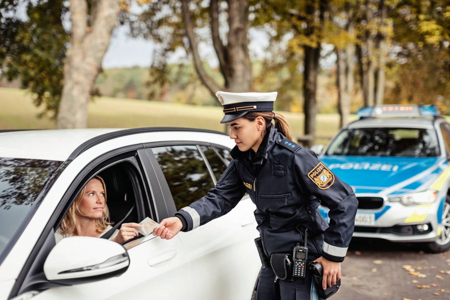 Dienstpistolen der deutschen Polizei "Aufmerksame Sicherungshaltung" einer Polizistin bei der Fahrzeugkontrolle