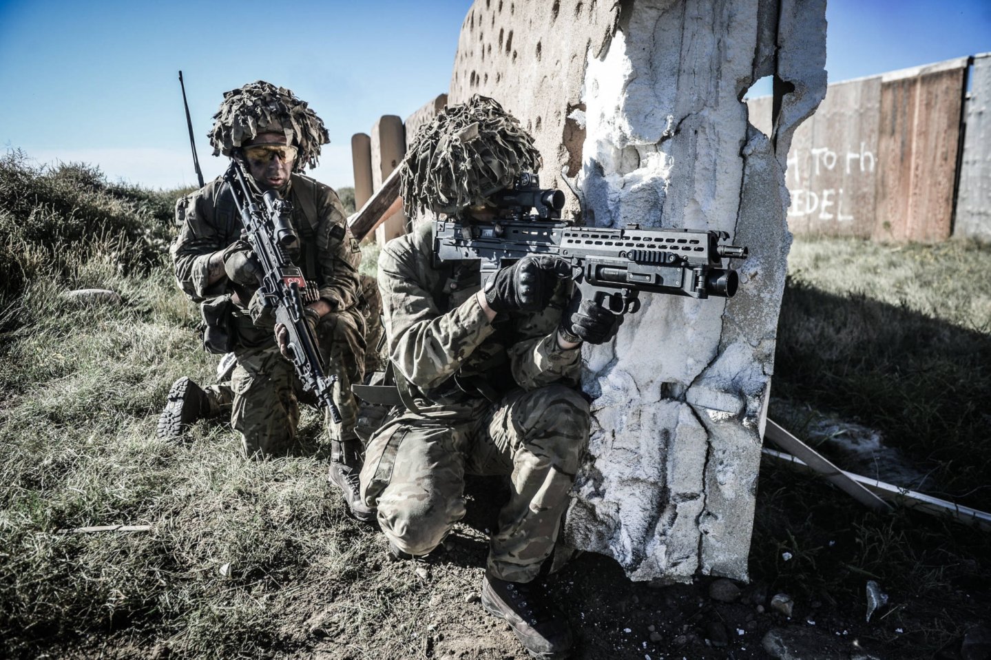 DSEI 2019: Heckler & Koch rüstet das Sturmgewehr SA80 der Britischen Armee auf. Soldaten mit SA80 an einer Mauer