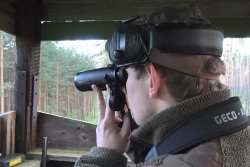 GECO Gold 10x42 und 10x50: die Ferngläser in der Jagdpraxis Jäger sitzt auf Hochsitz und glast mit GECO Gold Fernglas die Umgebung ab