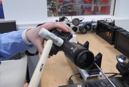 Wie entsteht ein Minox Zielfernrohr? Per Hammer wird das Zielfernrohr für den Schießfestigkeitstest bearbeitet.