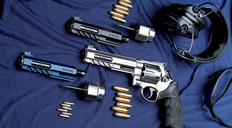 Der BBFC-Multikaliber-Matchrevolver vom S&W Club 30-Mitglied Thomas Spohr auf Basis des Smith & Wesson N-Rahmen-Modells 629 mit eingebautem .44 Magnum-System und danebenliegenden, einbaufertigen Wechselsystemen in .357 Magnum (links) und .22 Long Rifle (rechts) auf blauem Grund.