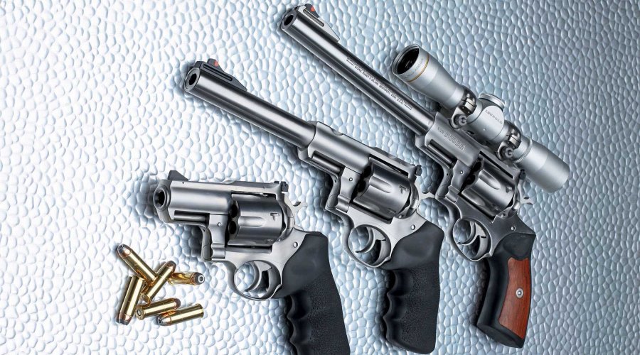 caliber 4/2017 Ruger Super Redhawks in den Lauflängen 9,5", 7,5" und 2,5" (von oben) mit Munition in .44 Magnum auf Glasplatte.