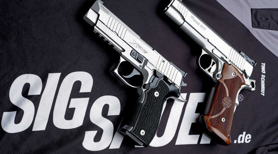 caliber 5/2017 SIG Sauer P226 X-Five und SIG Sauer 1911 Traditional Match Elite in der B&H-Edition in linker Seitenansicht auf einem schwarzen SIG-Sauer-T-Shirt.