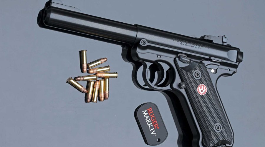 caliber 6/2017 Ruger Mark IV in linker Seitenansicht auf graublauem Hintergrund mit Kleinkaliber-Munition.