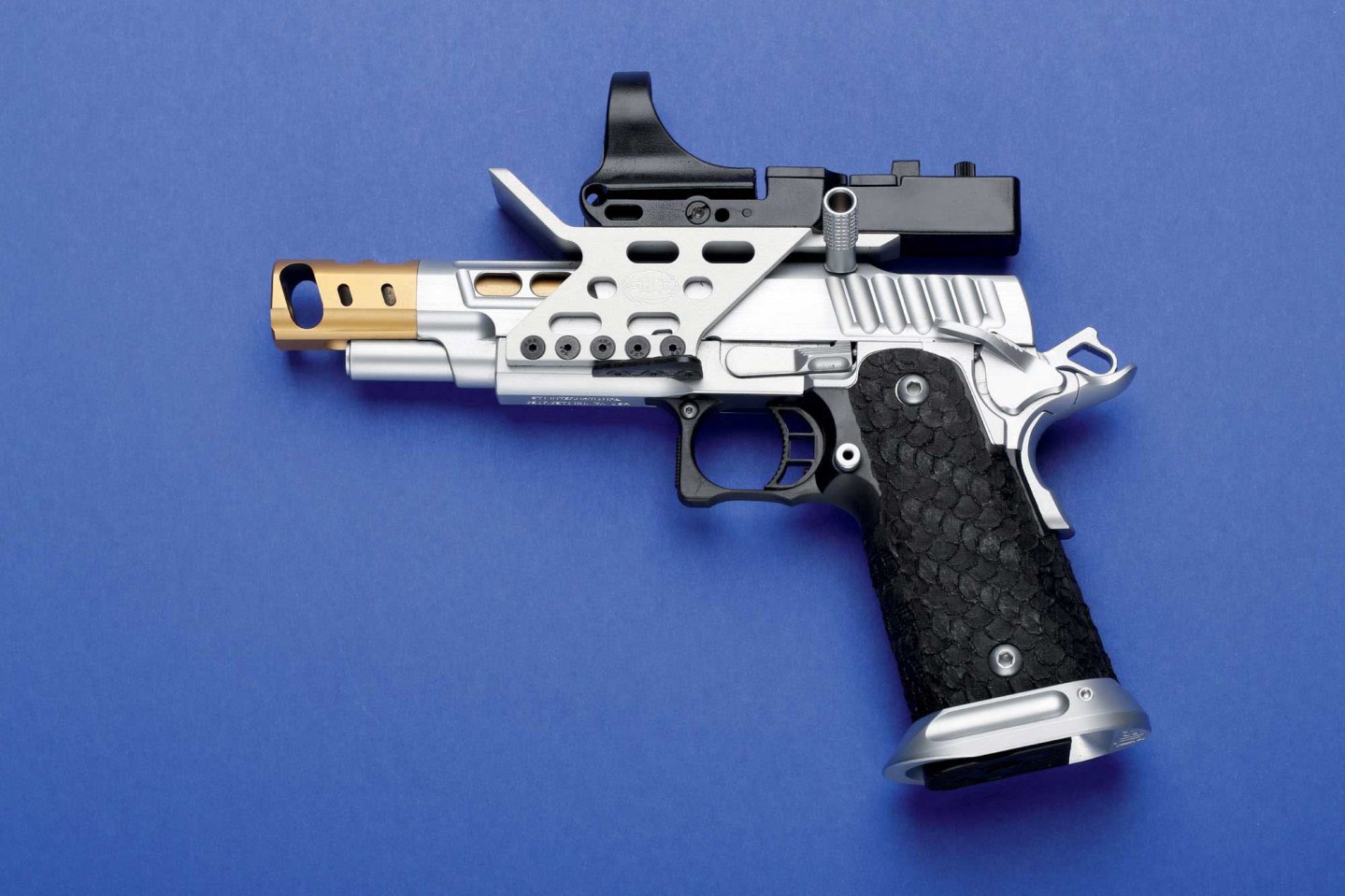 caliber 7+8/2017 STI International DVC Steel in linker Seitenansicht auf blauem Hintergrund.