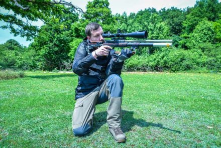 Field Target Schütze mit Luftgewehr in Schiessposition kniend
