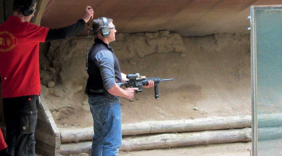 IPSC-Schütze mit Gewehr der AR-15-Familie in der Stage vor Beginn der Zeit