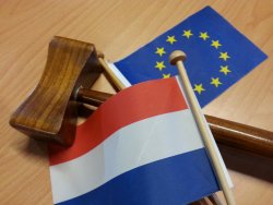 EU gun ban: this means war Dutch and European flags on the table, symbolizing the Dutch Presidency of the EU