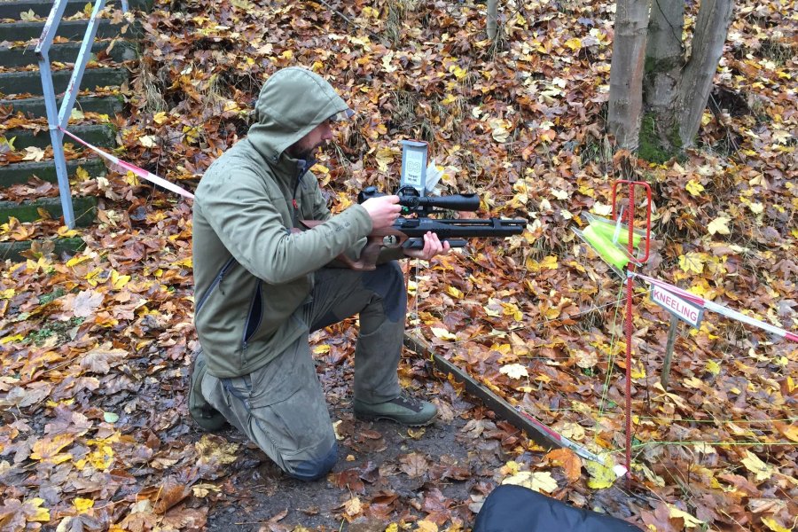 Was ist Field Target? – Der Schießsport im Überblick! Field-Target-Schütze im knienden Anschlag stellt sein Zielfernrohr auf dem Luftgewehr ein