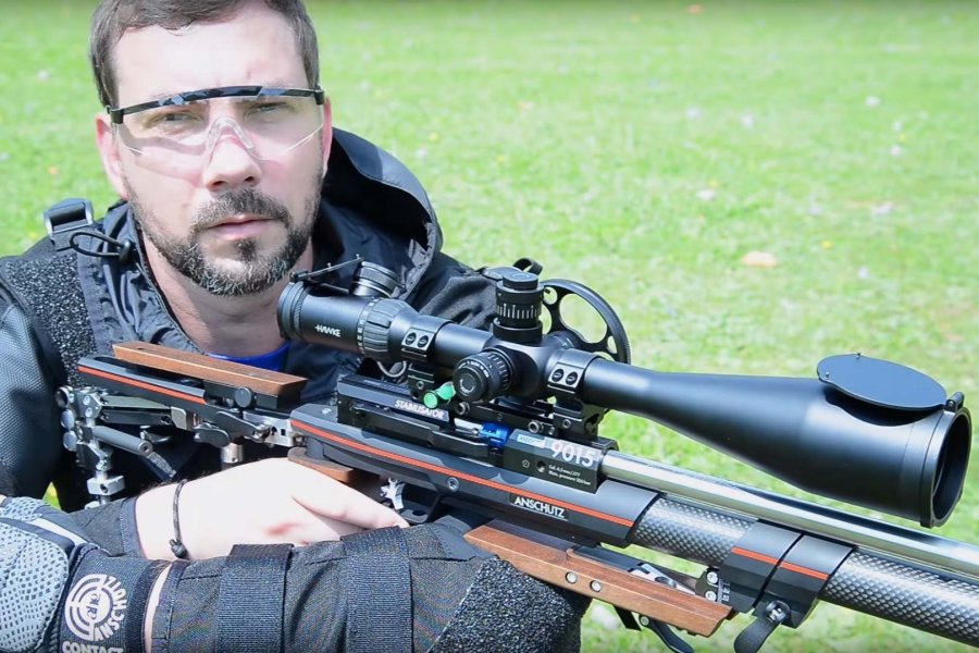 Was ist Field Target? – Der Schießsport im Überblick! Luftgewehrschütze in Field Target Standardposition sitzend mit Luftgewehr samt Zielfernrohr