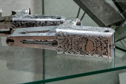 Filigranes Handwerk: Angehende Graveure – ein Besuch Kipplaufsysteme mit aufwändiger Gravur in einer Vitrine.