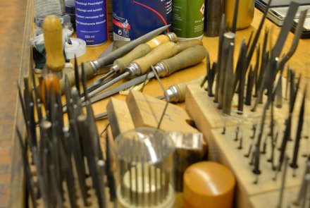 Filigranes Handwerk: Angehende Graveure – ein Besuch Werkzeugportfolio für Graveure auf einer Werkbank.