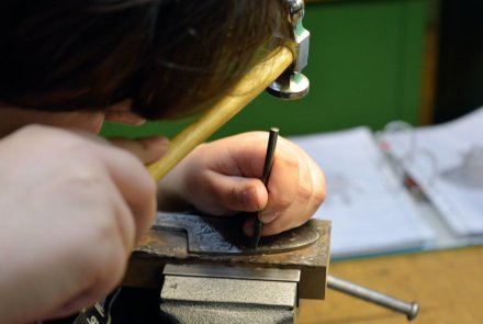 Filigranes Handwerk: Angehende Graveure – ein Besuch Detail der Arbeit an einer Seitenplatte für eine Kippflaufwaffe.