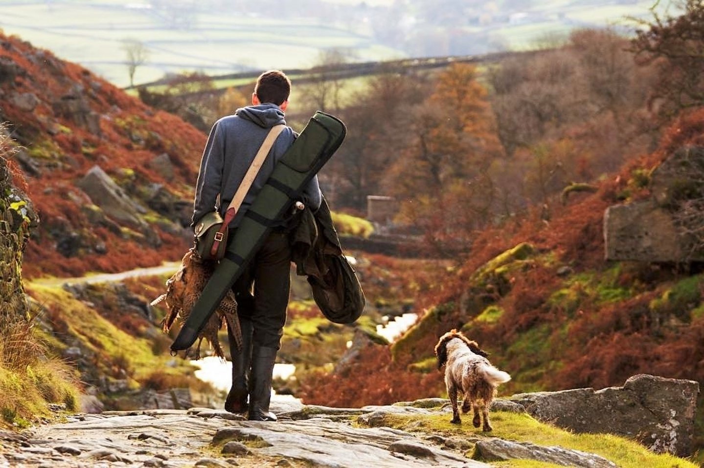 Jungjäger-Aktion auf LuckyShoot.eu: Fabarm ELOS Flinten auf der neuen Online-Auktionsplattform günstiger Jungjaeger mit flinte, erlegtem vogelwild und jagdhund von hinten vor landschaft