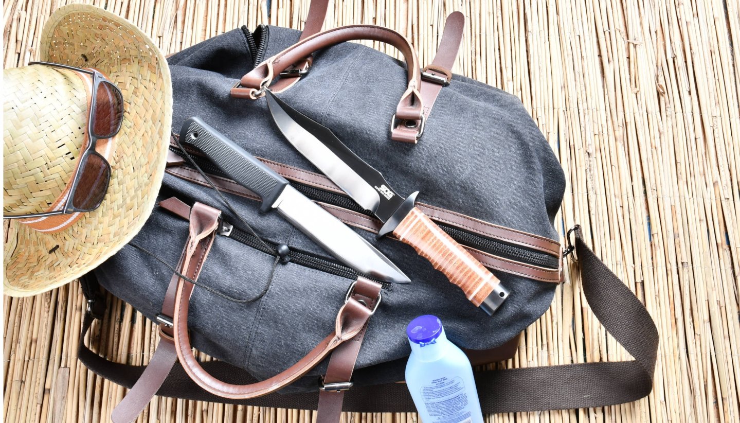 Zwei große Messer auf einer Reisetasche.